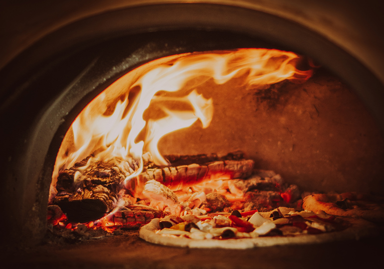Pizza cooking in Dough Man's Land high-temperature pizza oven