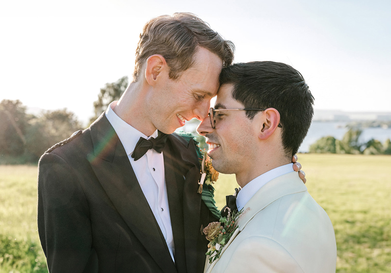 Same-sex couple sharing a relaxed wedding portrait in the Scottish countryside