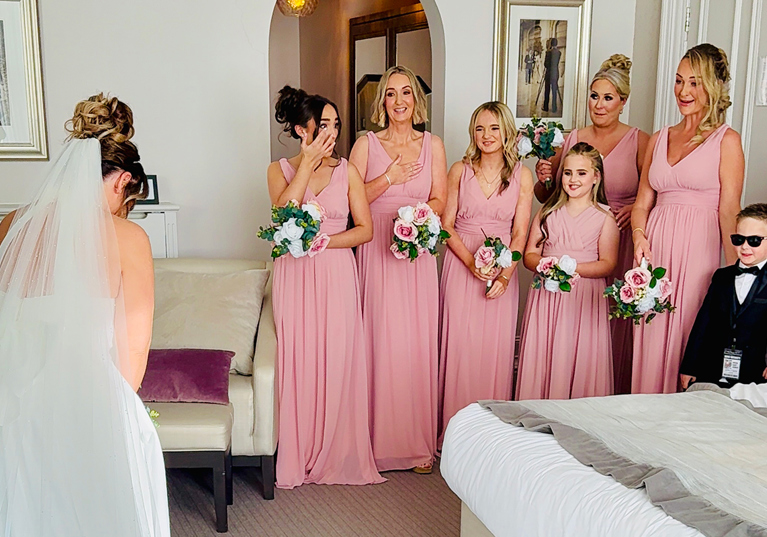 Emotional bridesmaids reacting to the bride’s wedding dress reveal during bridal preparations captured by Effortless Ivory Weddings