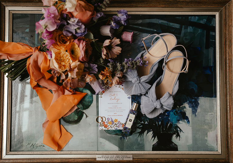 Wedding detail flat lay with orange and purple bridal bouquet by Agapanthus Flower Studio