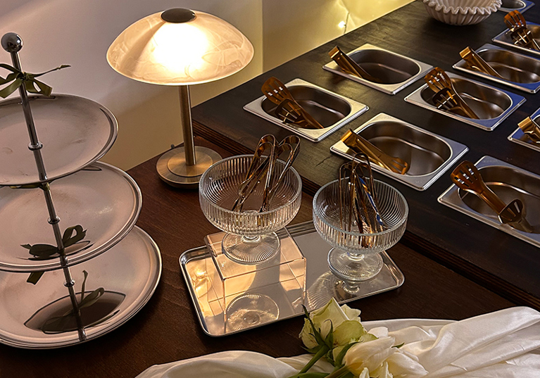 Bramble & Brie hot grazing table with gold serving dishes, glass bowls and white wedding flowers