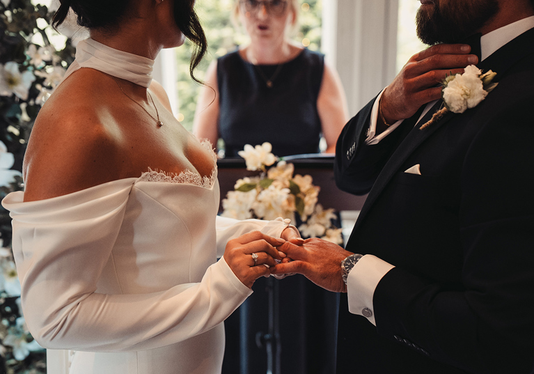 Bride places a wedding ring on the groom’s finger during a ceremony conducted by Fiona MacAlister Celebrant.