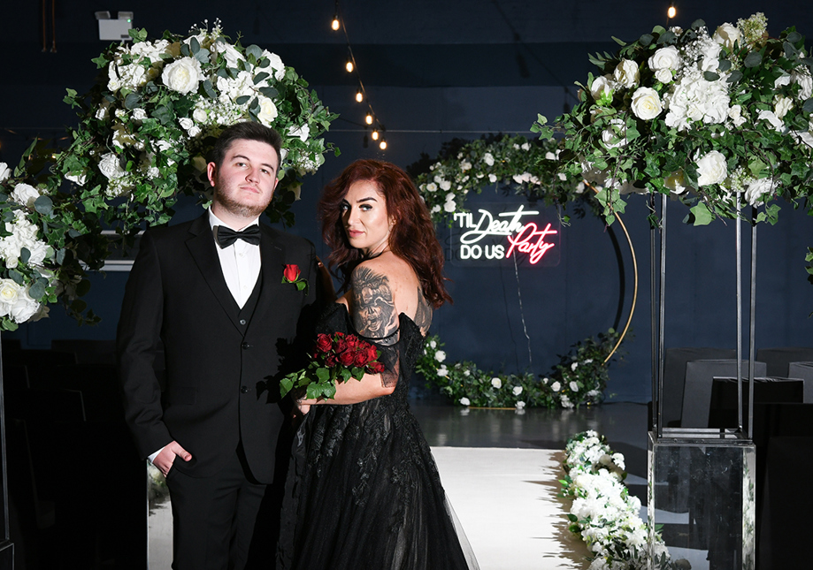 Wedding photoshoot at Geilsland Estate with decor by Enlighten My Day, featuring models Greg Russell and Morgan Thom from Devotion Weddings in front of a neon “Till Death Do Us Party” sign.