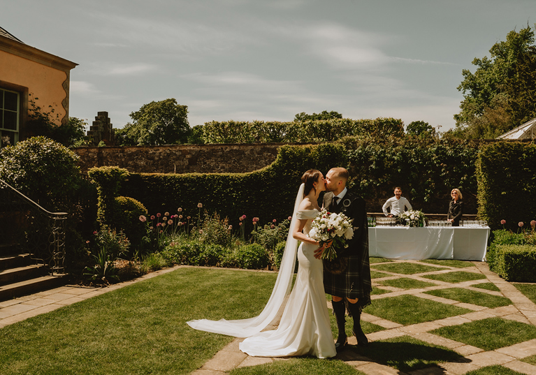 Bride and groom kissing in the gardens at Jupiter Artland wedding venue near Edinburgh