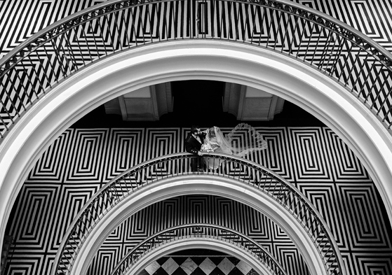 Black-and-white portrait of newlyweds on the distinctive curved staircase at The Edinburgh Grand.