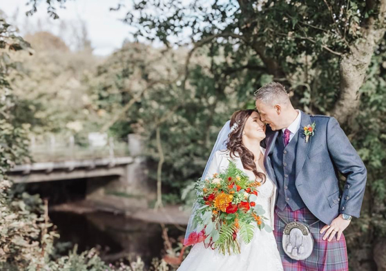 Bride and groom portrait in the woodland grounds at Dalgarven House with autumn bouquet and groom in kilt