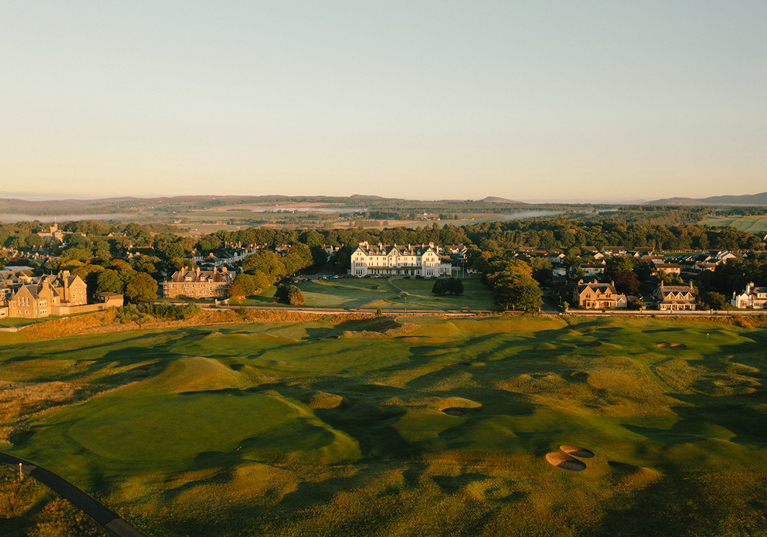 Aerial view of Dornoch Station Hotel wedding venue with championship golf course in the foreground and Scottish Highlands landscape beyond