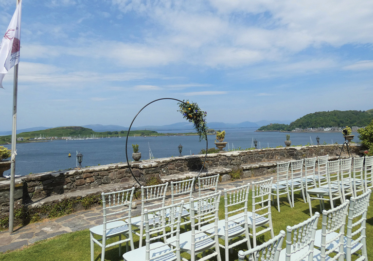Outdoor ceremony set up on the grounds of Dungallan Country House with hoop at altar and views across the water.