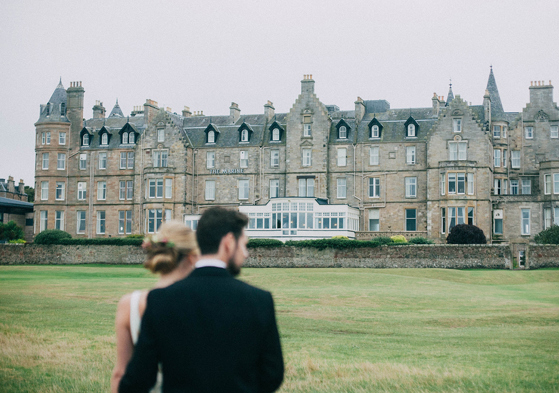 Couple walking on the lawn in front of Marine North Berwick hotel wedding venue in Scotland