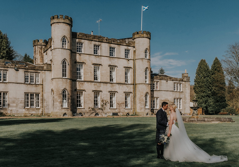Bride and groom portrait on the lawn in front of Melville Castle in Scotland.