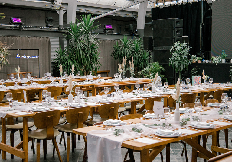 Wedding meal set up on wooden tables with white and green decor at BAaD Glasgow.