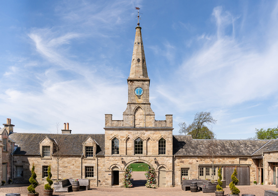 Historic stone entrance and clock tower at Rosebery House exclusive-use wedding venue in Scotland