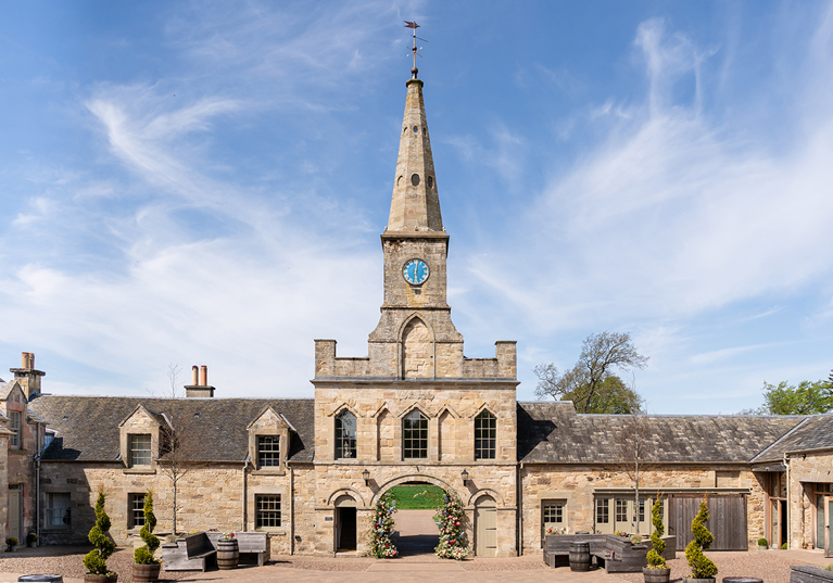 Historic stone entrance and clock tower at Rosebery House exclusive-use wedding venue in Scotland