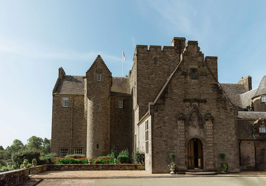 Exterior of Rowallan Castle wedding venue with stone walls and blue sky