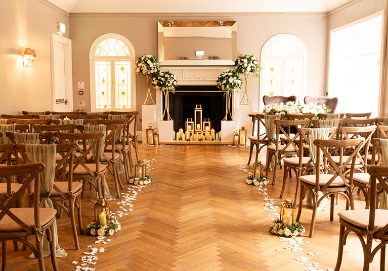 Romantic wedding ceremony at Strathaven Hotel with candlelit fireplace, floral arrangements and aisle décor.