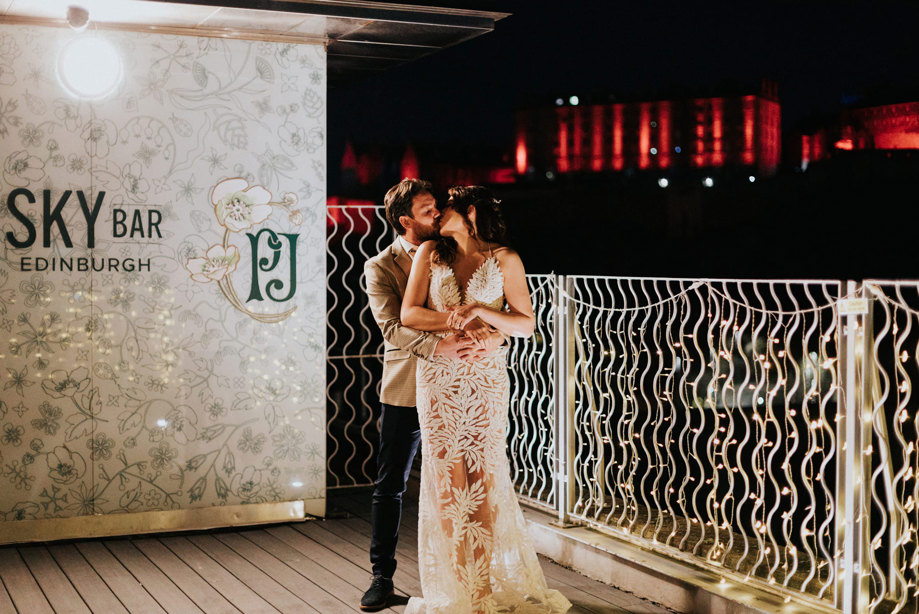 bride and groom stand on outside terrace during wedding at Doubletree By Hilton Edinburgh Skybar 