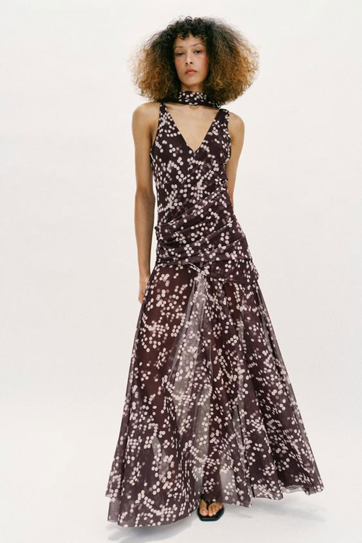 Dark brown tulle maxi dress with white speckled pattern and layered skirt styled in a studio setting