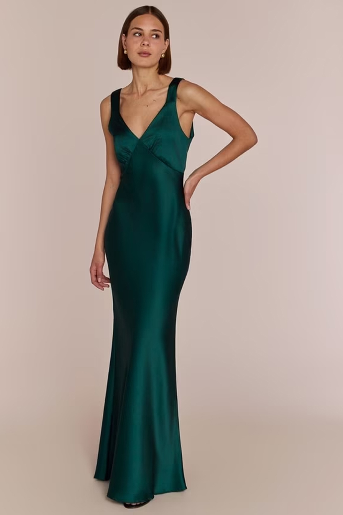Model wearing a forest-green satin maxi dress with a V-neckline and fitted, flared silhouette.