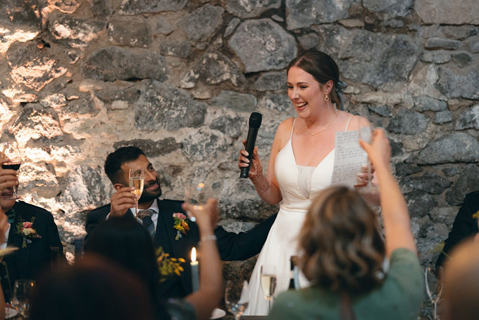 A person in a white dress holding a microphone and a person in a suit.