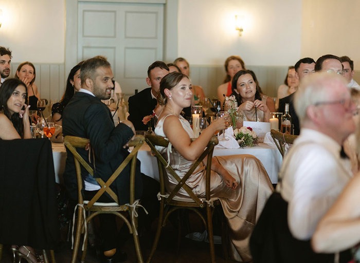 a group of people seated at tables at a wedding