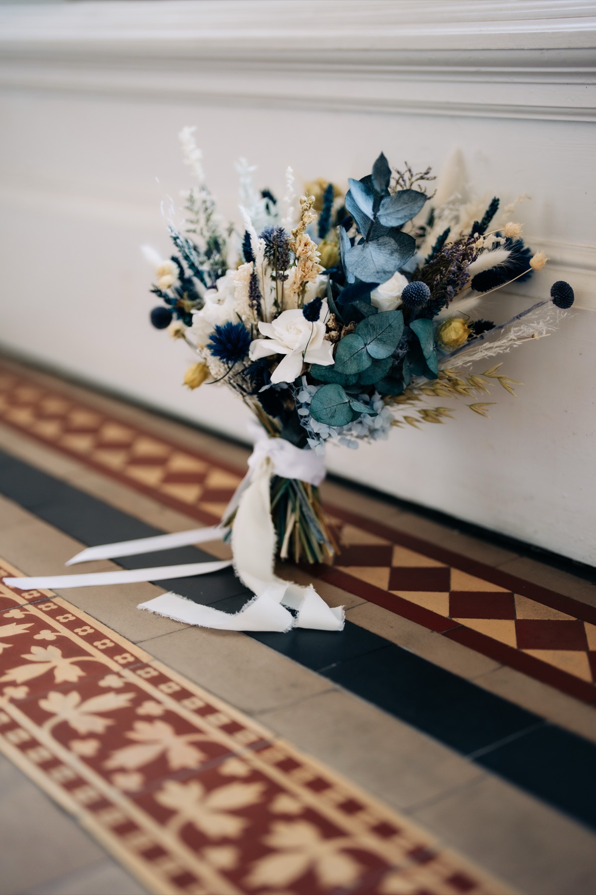  Blue-and-white dried bridal bouquet featuring thistles, eucalyptus and preserved flowers for Robyn and James's Òran Mór wedding in Glasgow.