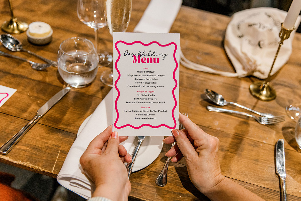 Colourful wedding menu card displayed on a styled reception table