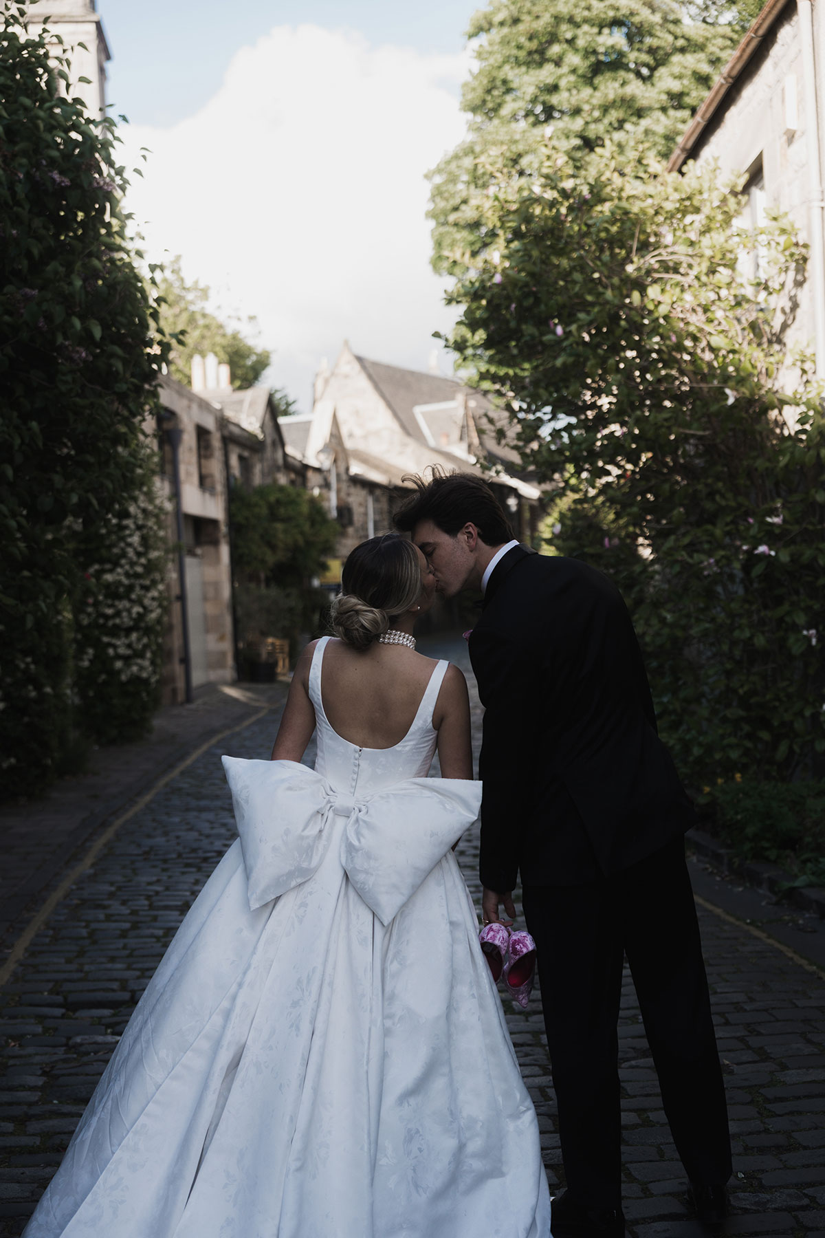 Bride and groom sharing a kiss in an Edinburgh mews street on their wedding day