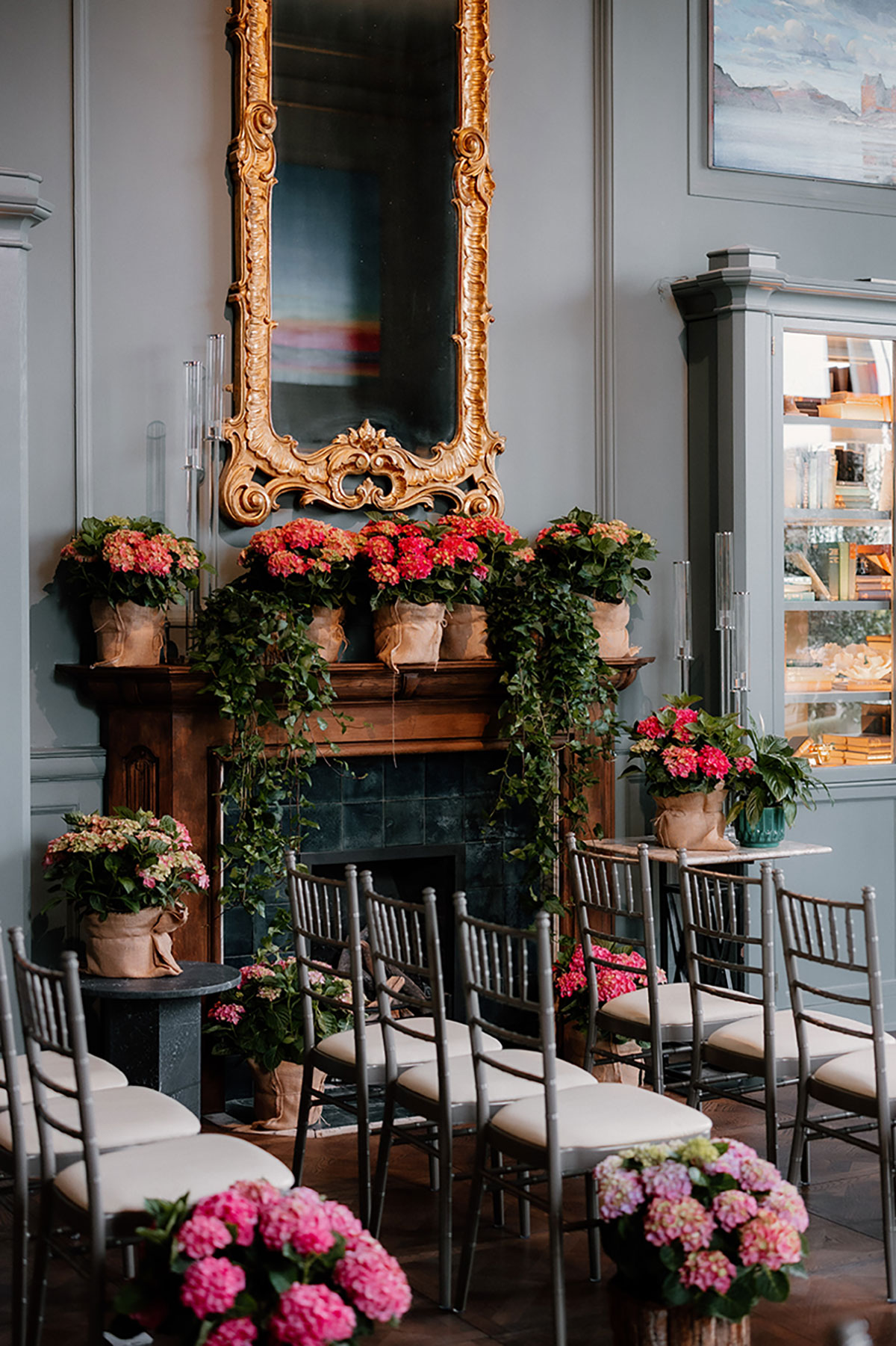 Wedding ceremony room at Mar Hall decorated with pink hydrangeas, greenery and a gold ornate mirror.