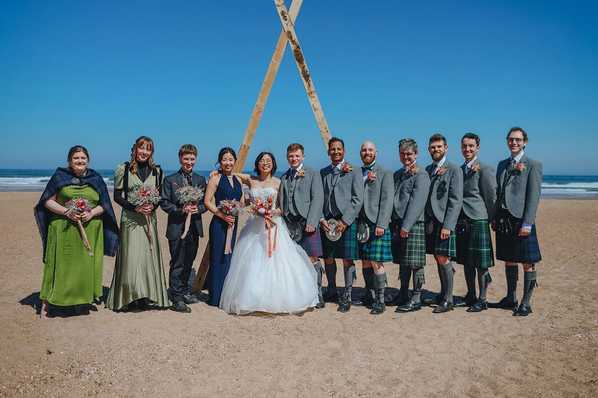 Wedding party group photo on the beach at Harvest Moon Weddings in East Lothian