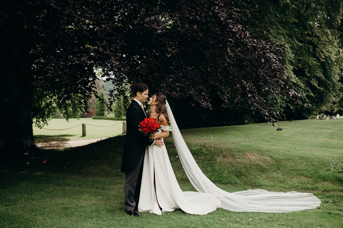 A bride and groom kissing in a garden at Achnagairn Castle