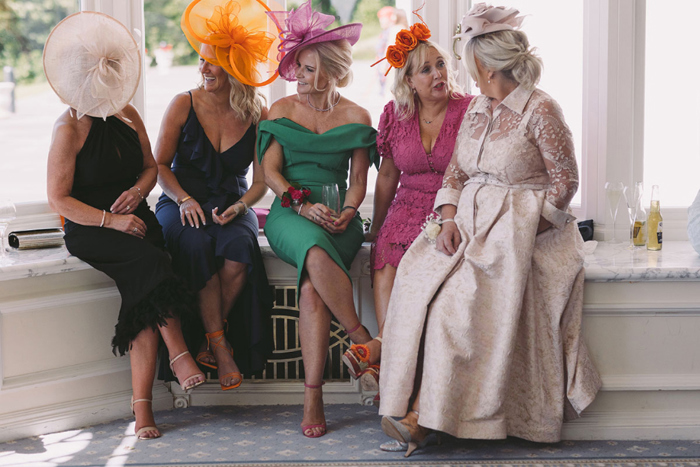 Guests wearing brightly coloured dresses and hats