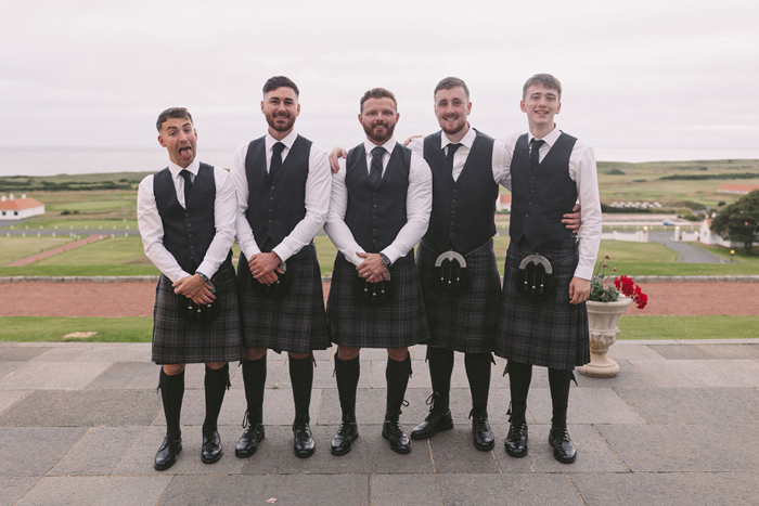Groom and four groomsmen wearing kilts