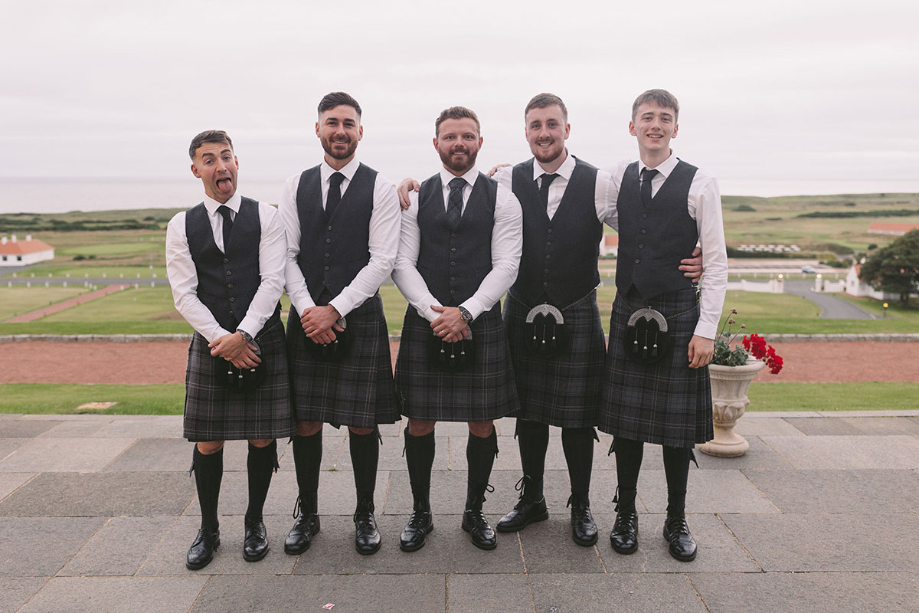Groom and four groomsmen wearing kilts