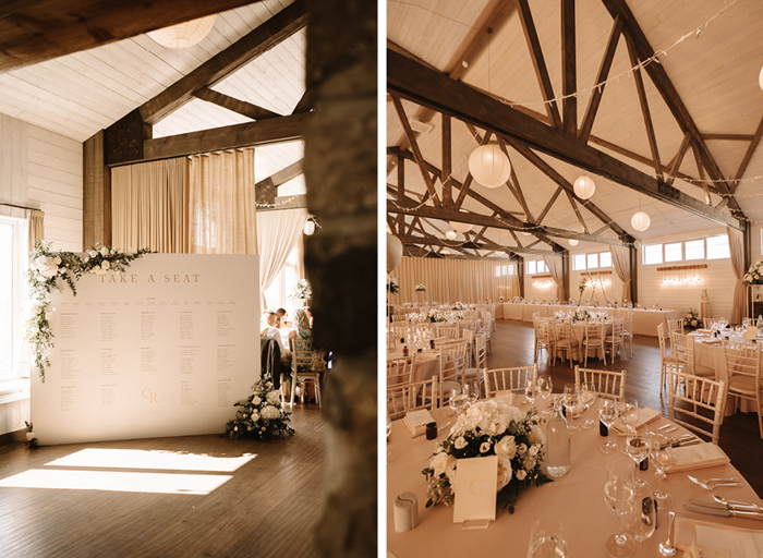 a large white wedding seating plan sitting on a wooden floor with white flowers in each corner on left. The interior of the Barn @ Barra Castle set for a wedding meal with round tables and chiavari chairs
