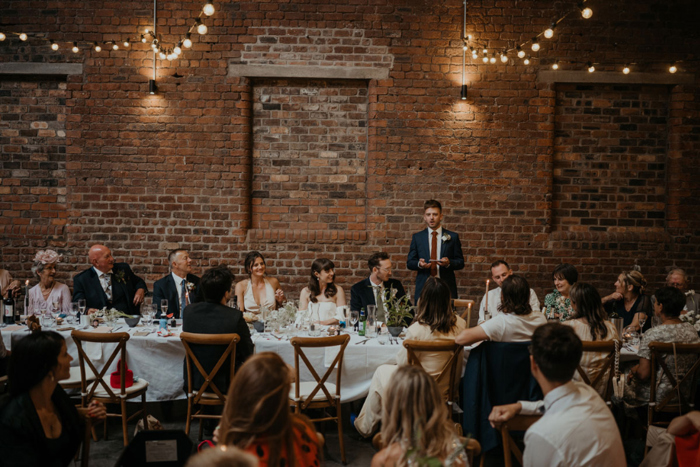 Top table of their wedding listen to a speech
