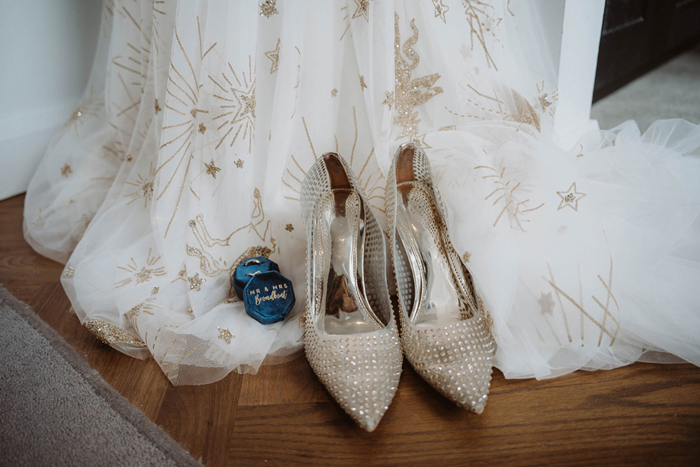 Bride's celestial wedding dress, gold heels and rings in blue box
