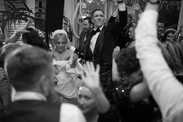 A black and white photo of a crowd celebrating at a wedding