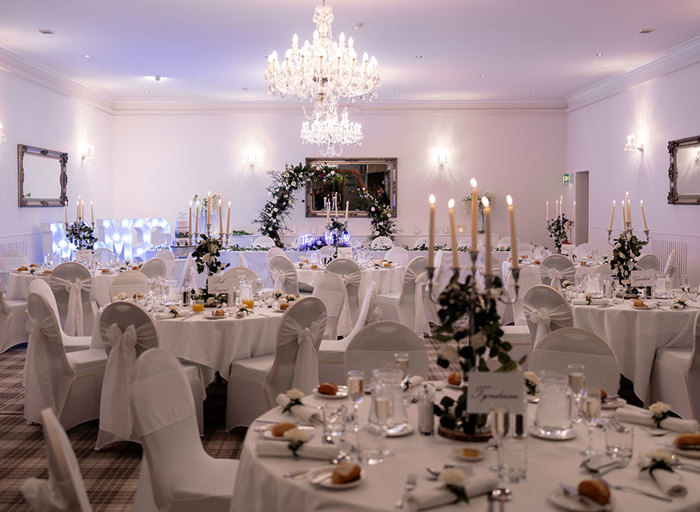 Revack Suite at Nethybridge Hotel set for a wedding dinner with white chairs with tie backs