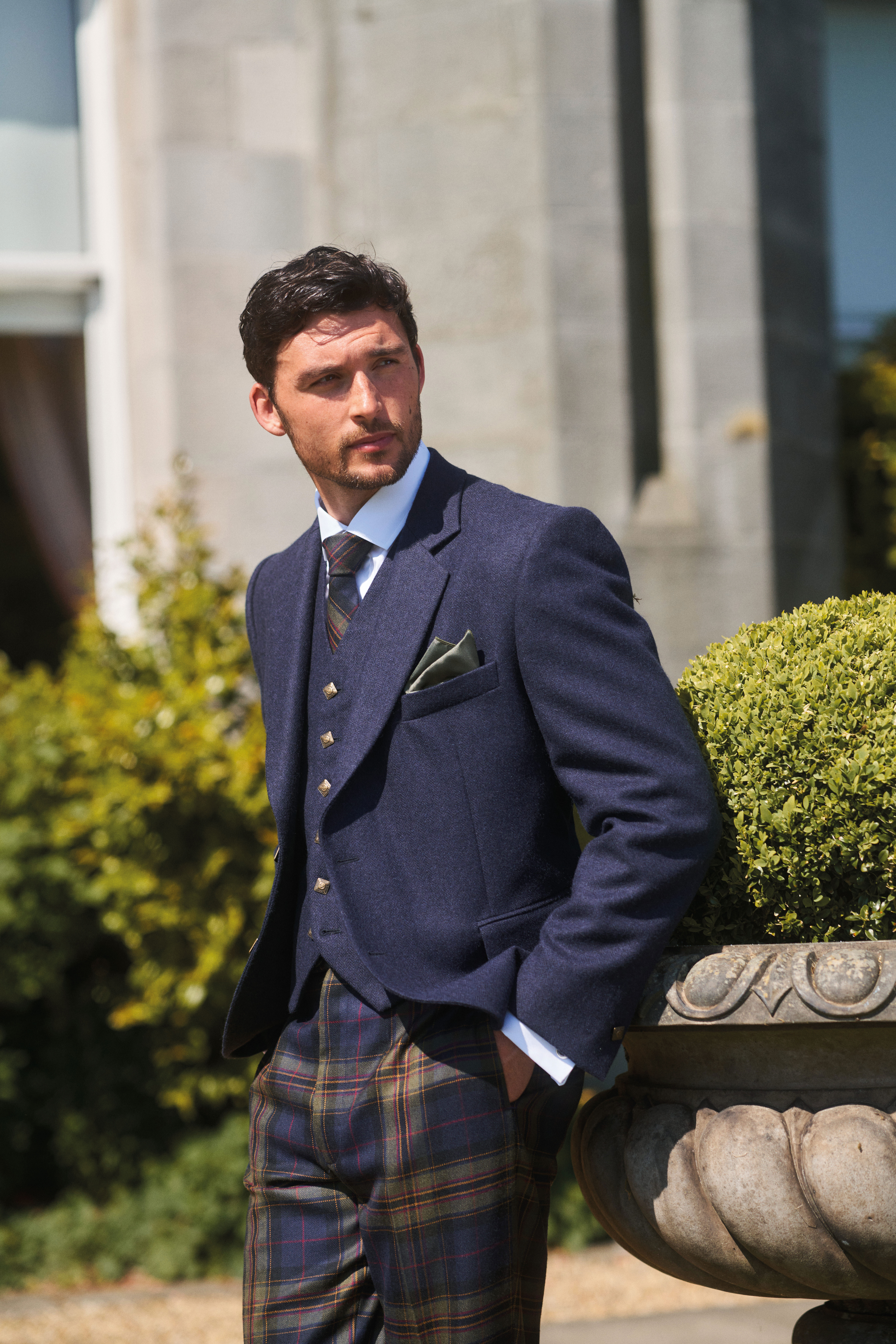 close up of groom wearing navy jacket paired with mccalls highlandwear's new noble print tartan trews