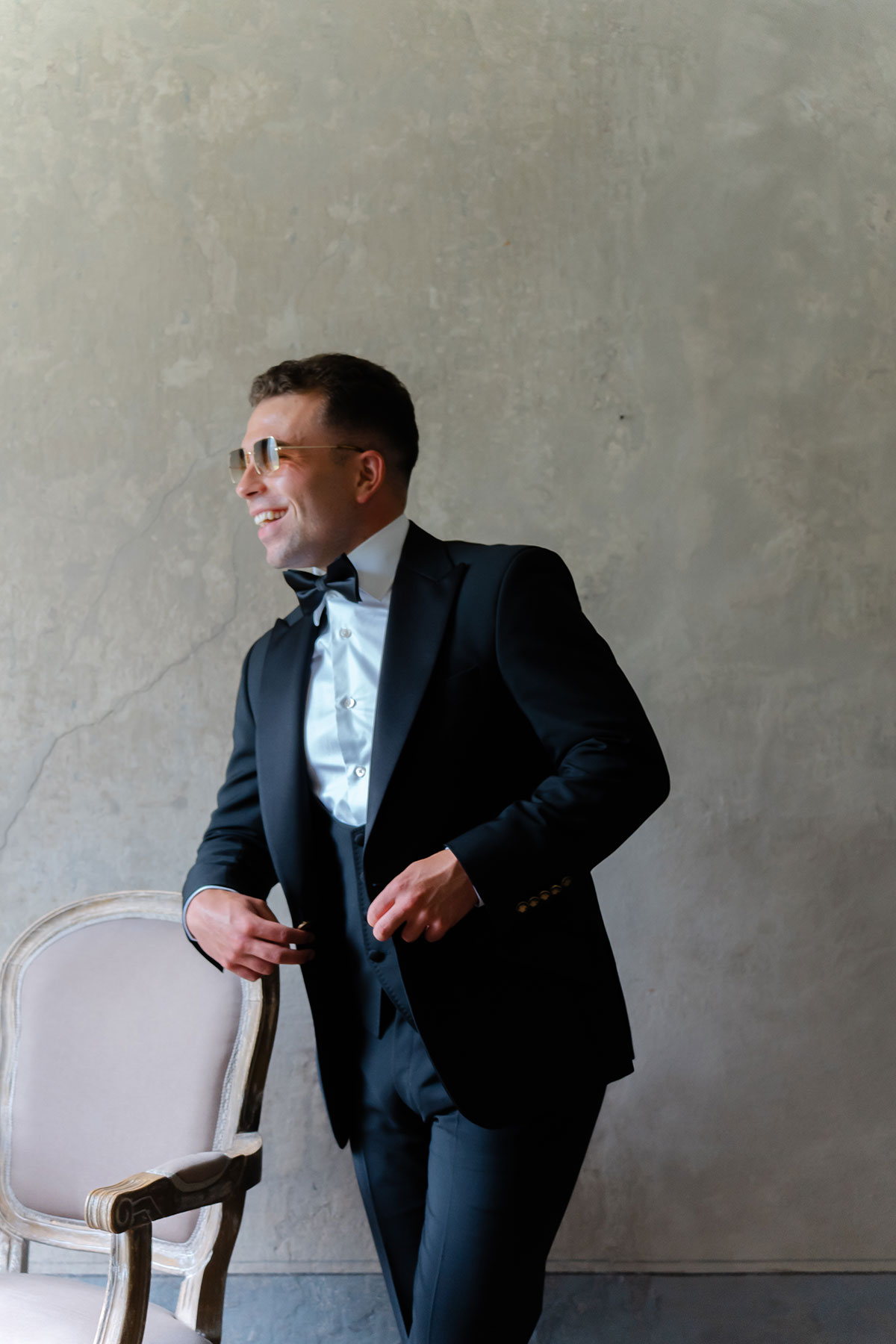 Groom wearing a black tuxedo and bow tie during preparations for a Lake Como wedding.