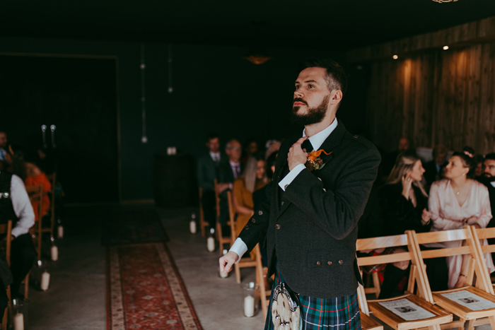 Groom waits at the top of the aisle