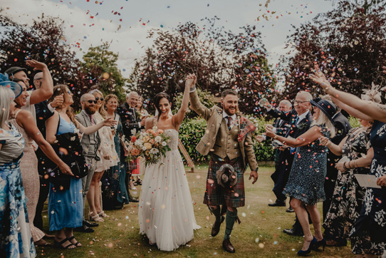 Couple walk through confetti shower