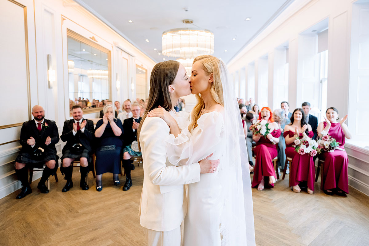 Brides share a kiss during wedding ceremony at The Exchange Glasgow.