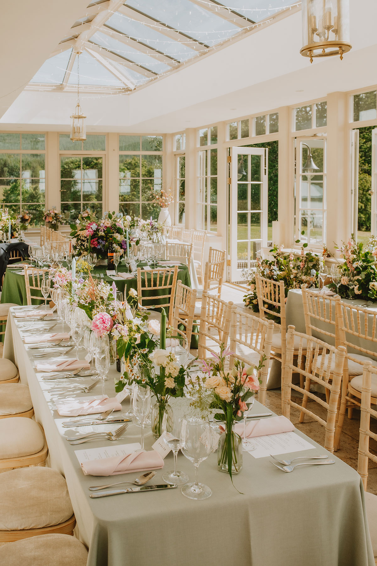 Marquee wedding reception with long tables, floral arrangements and glass roof at Ballogie Estate