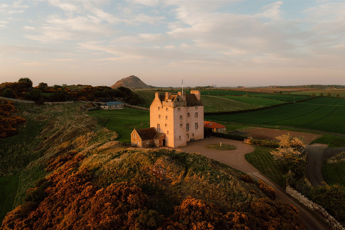 Aerial view of Fenton Tower surrounded by countryside and farmland in East Lothian