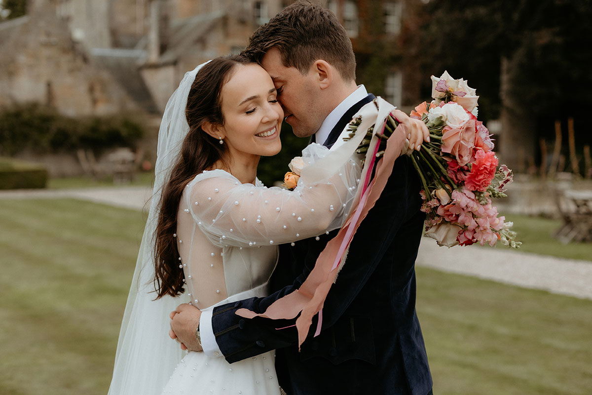 a bride and groom hugging in the garden at Carlowrie Castle