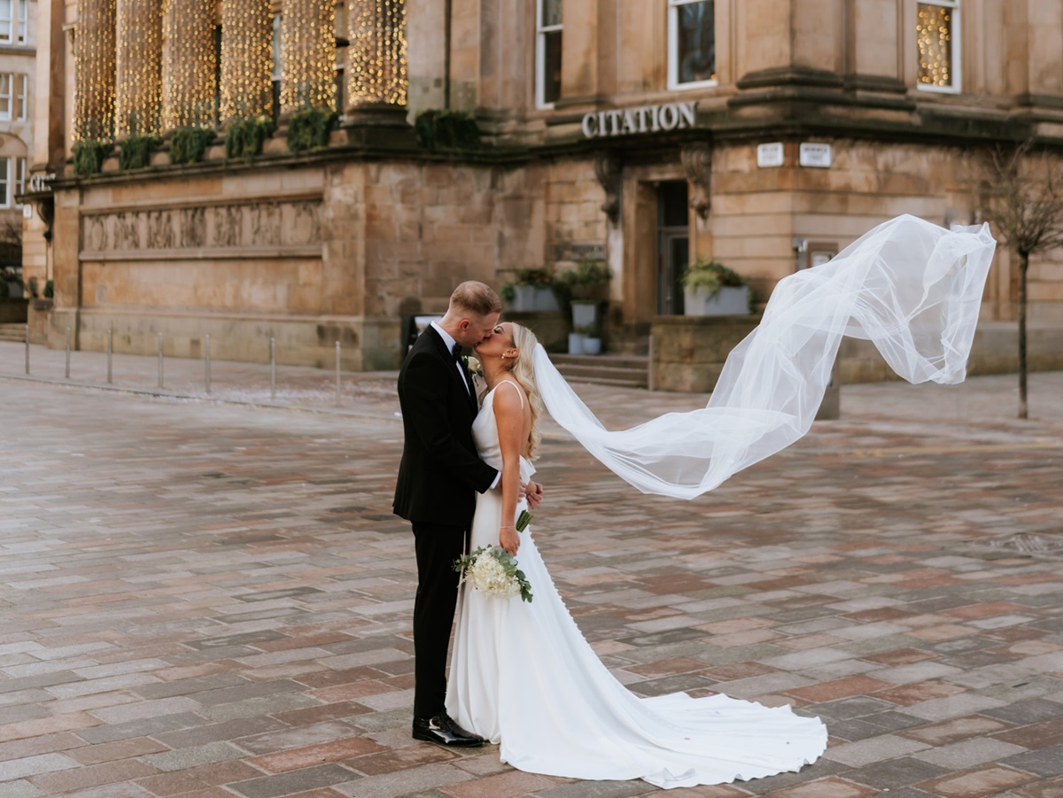 a bride and groom kissing outside Citation wedding venue in Glasgow