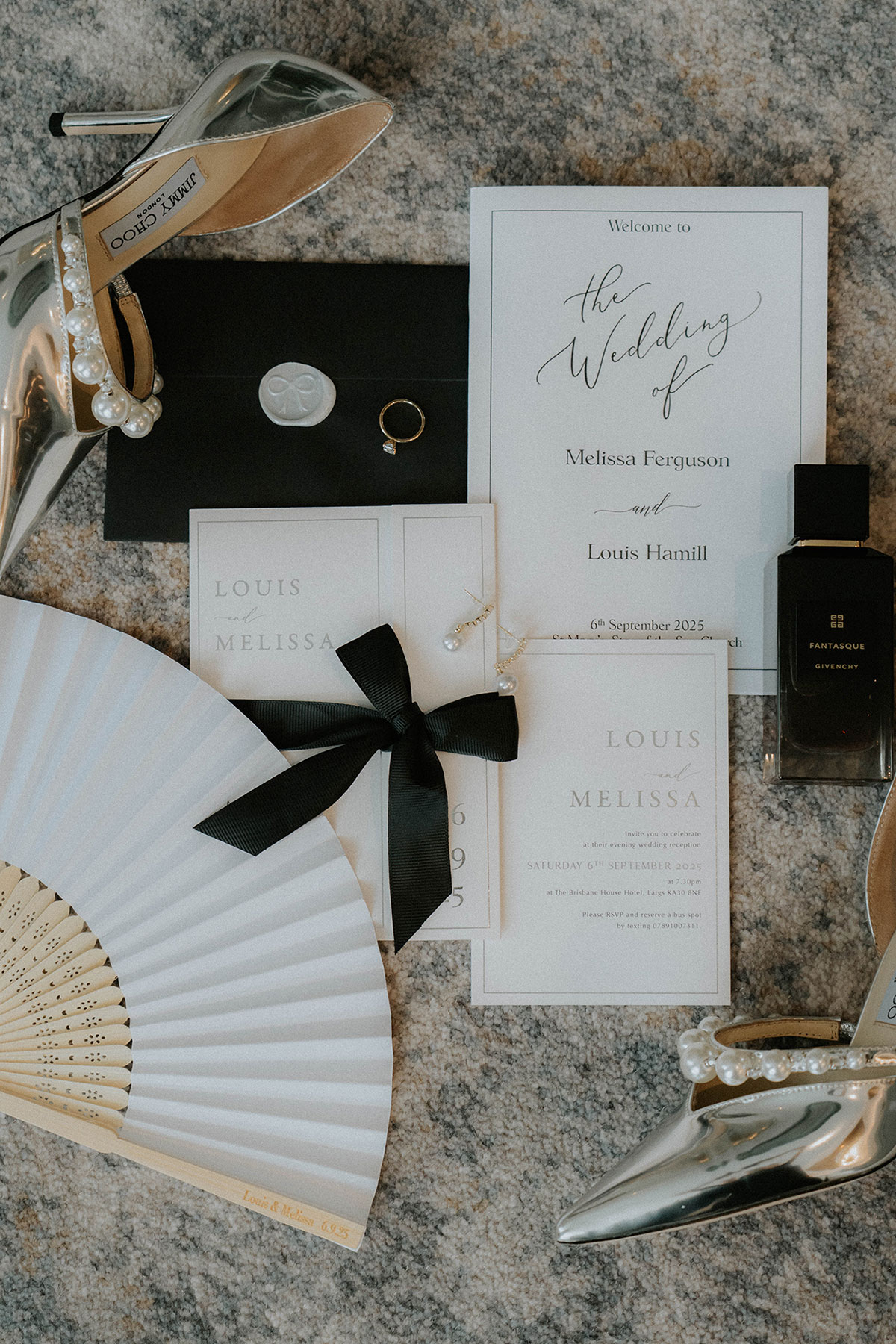Monochrome wedding stationery flatlay with pearl heels, black ribbon fan, perfume and personalised invitations at Brisbane House Hotel