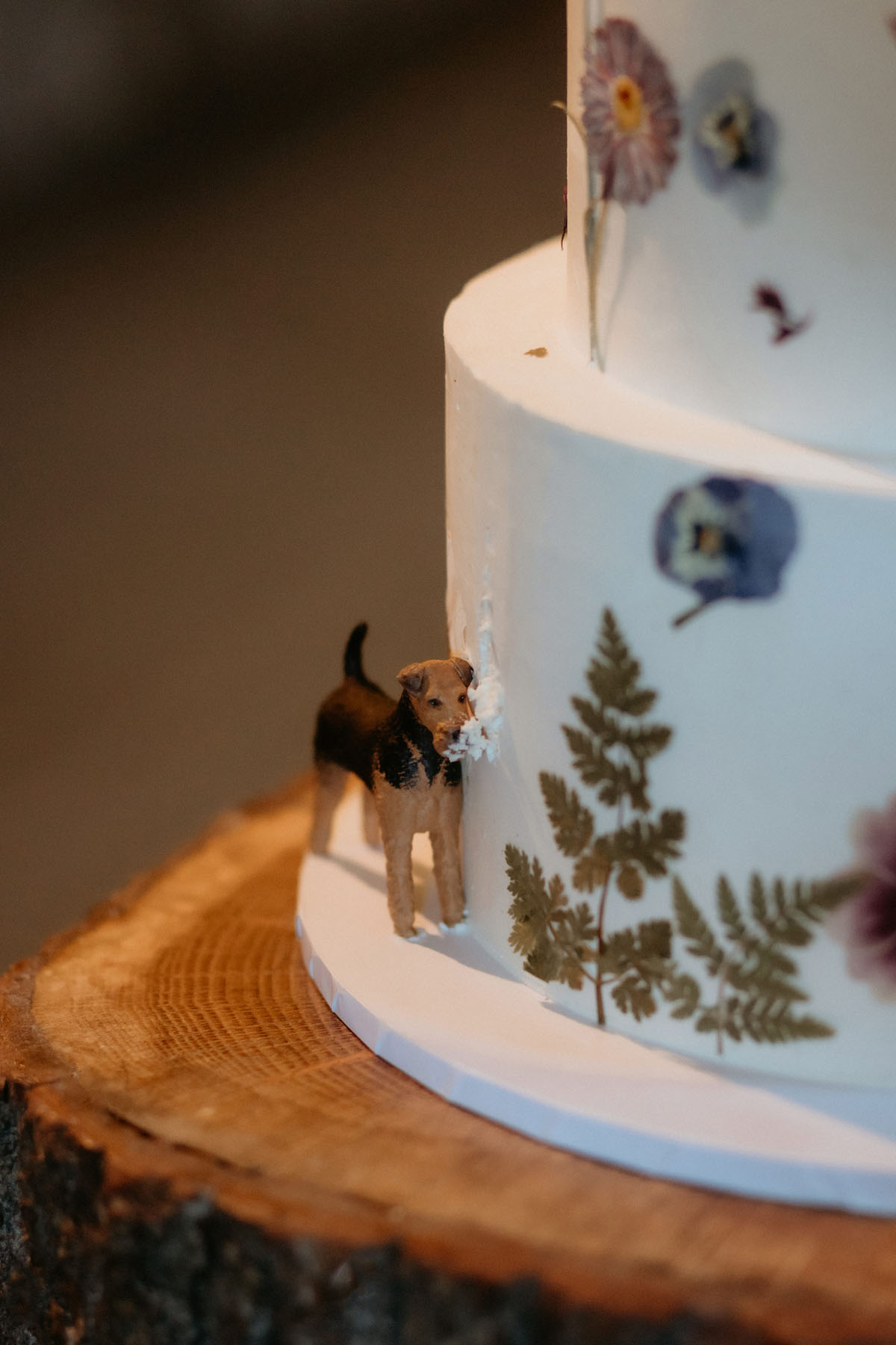 Floral wedding cake at The Byre at Inchyra featuring a small dog figurine detail on the side.