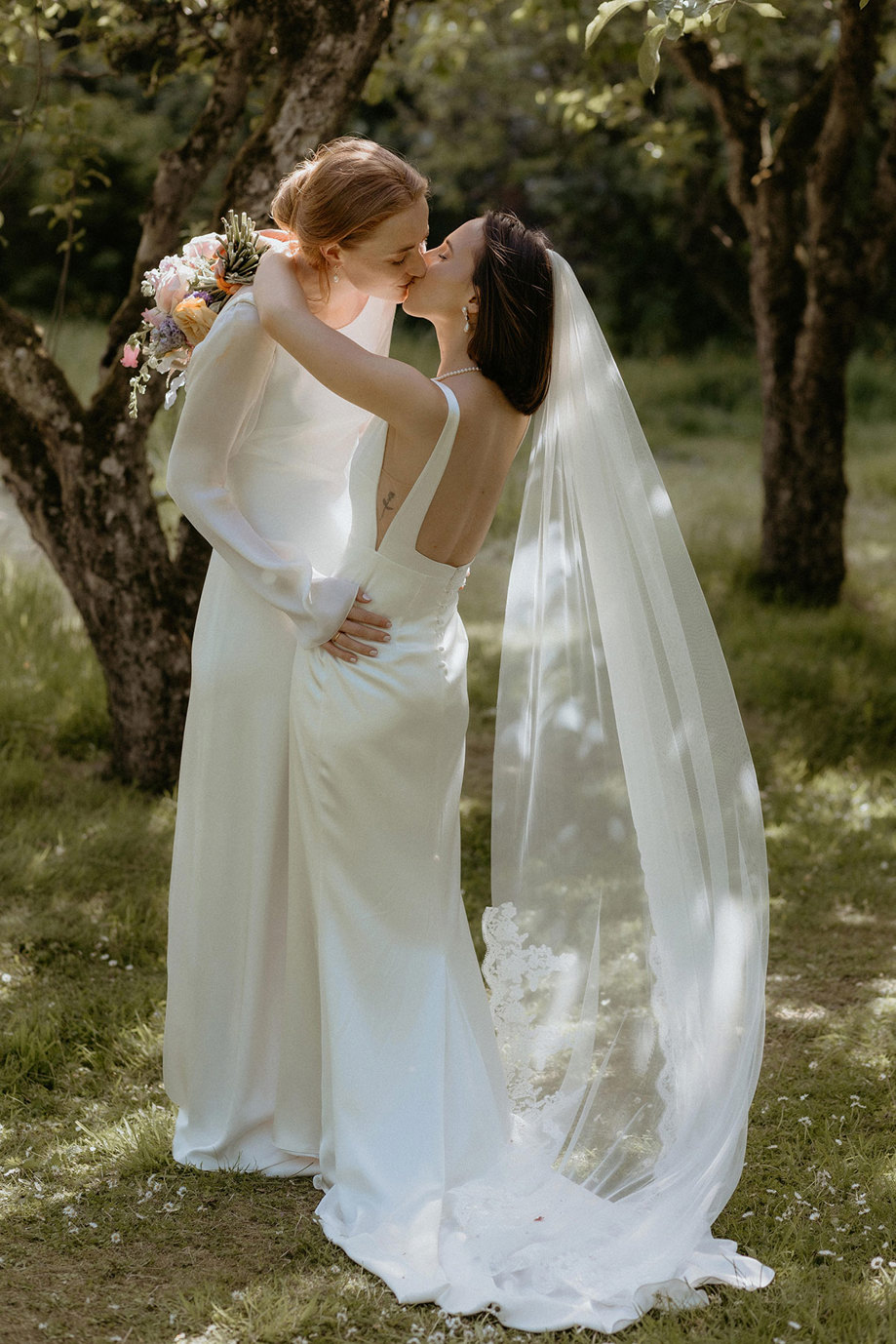 two brides kissing in garden at the Byre at Inchrya
